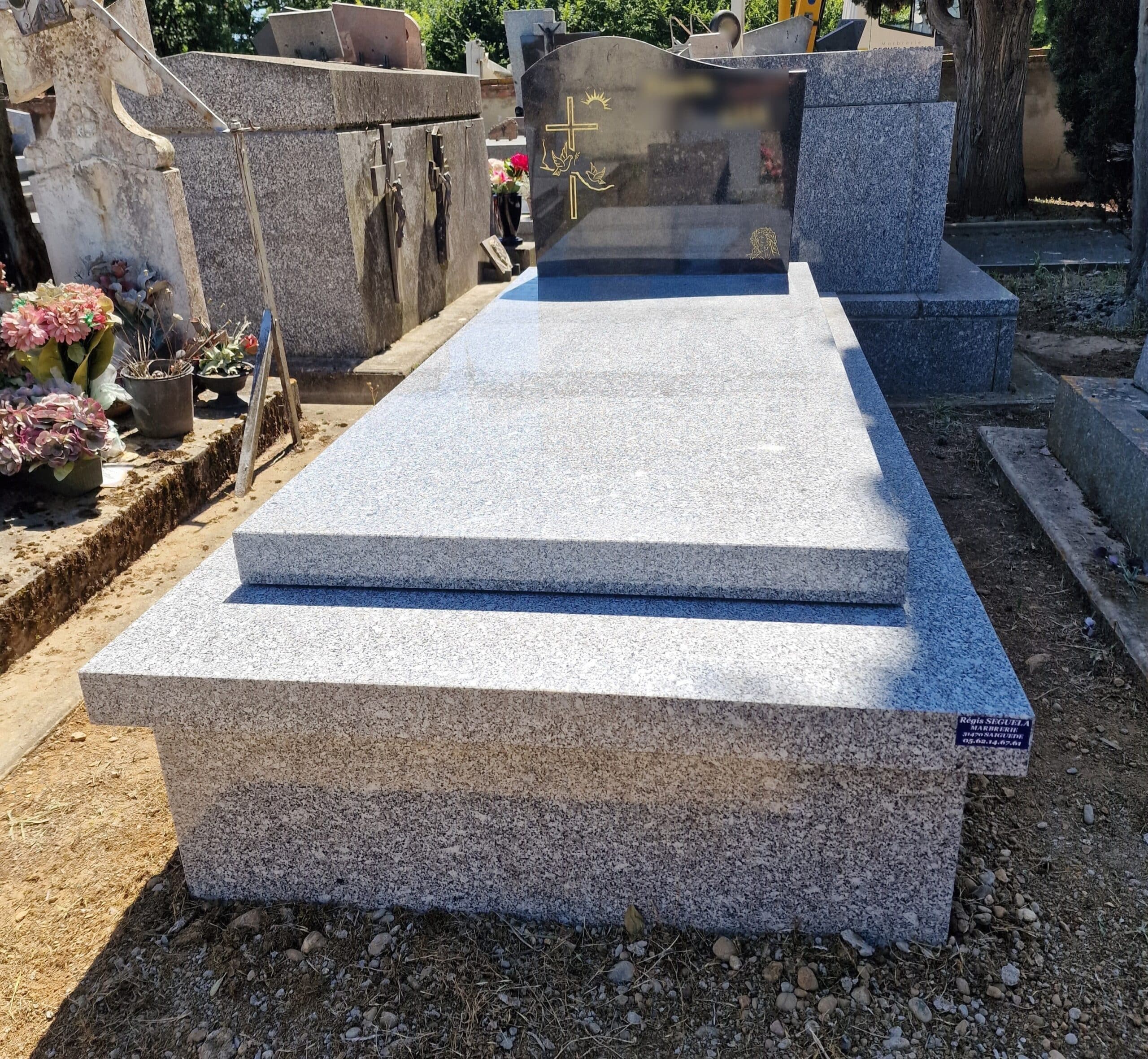 Pierre tombale moderne en granit gris avec stèle noire ornée d'une croix dorée et colombes au cimetière.
