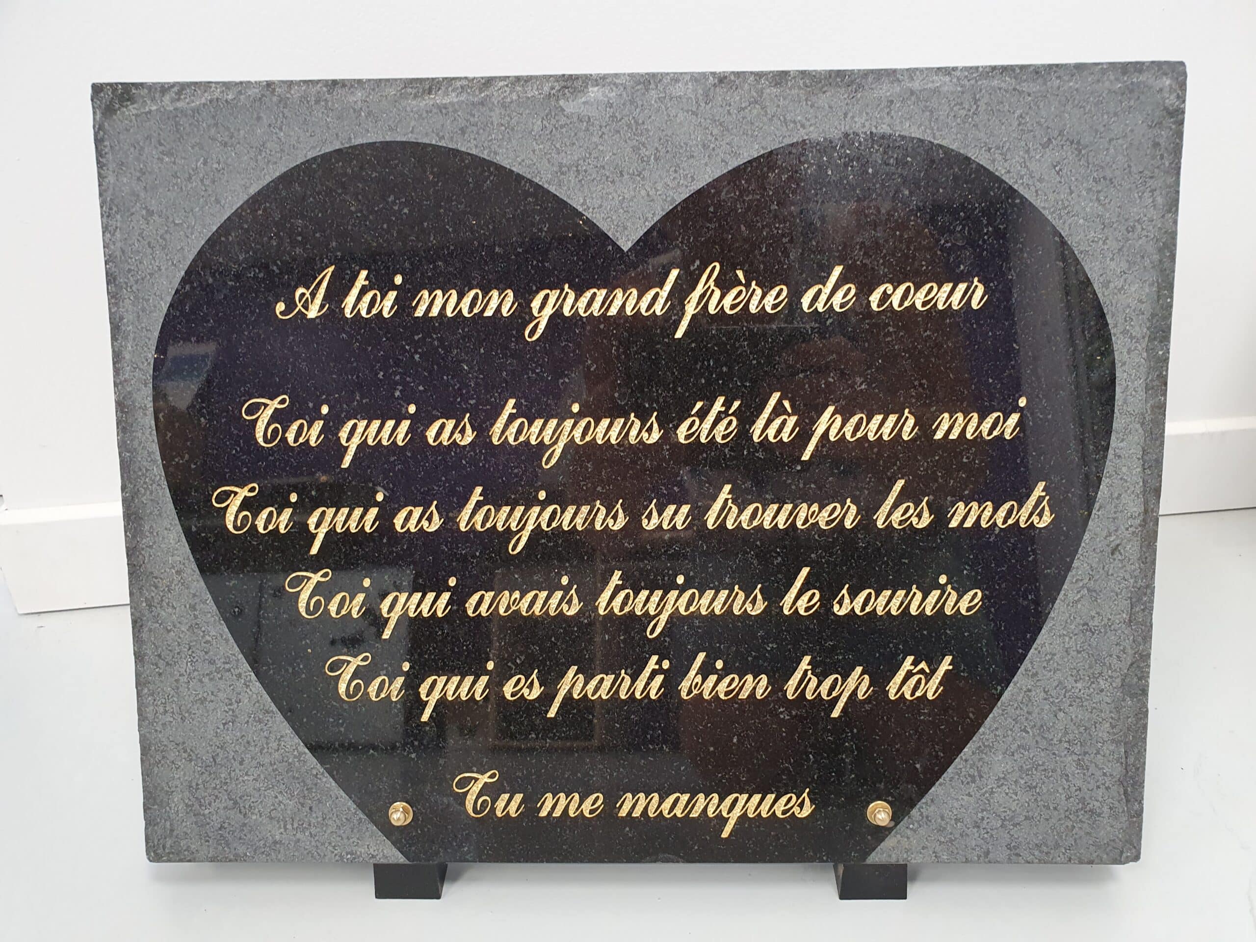 Plaque funéraire cœur en granit noir, texte doré 'À toi mon grand frère de cœur, tu me manques', hommage et souvenir.