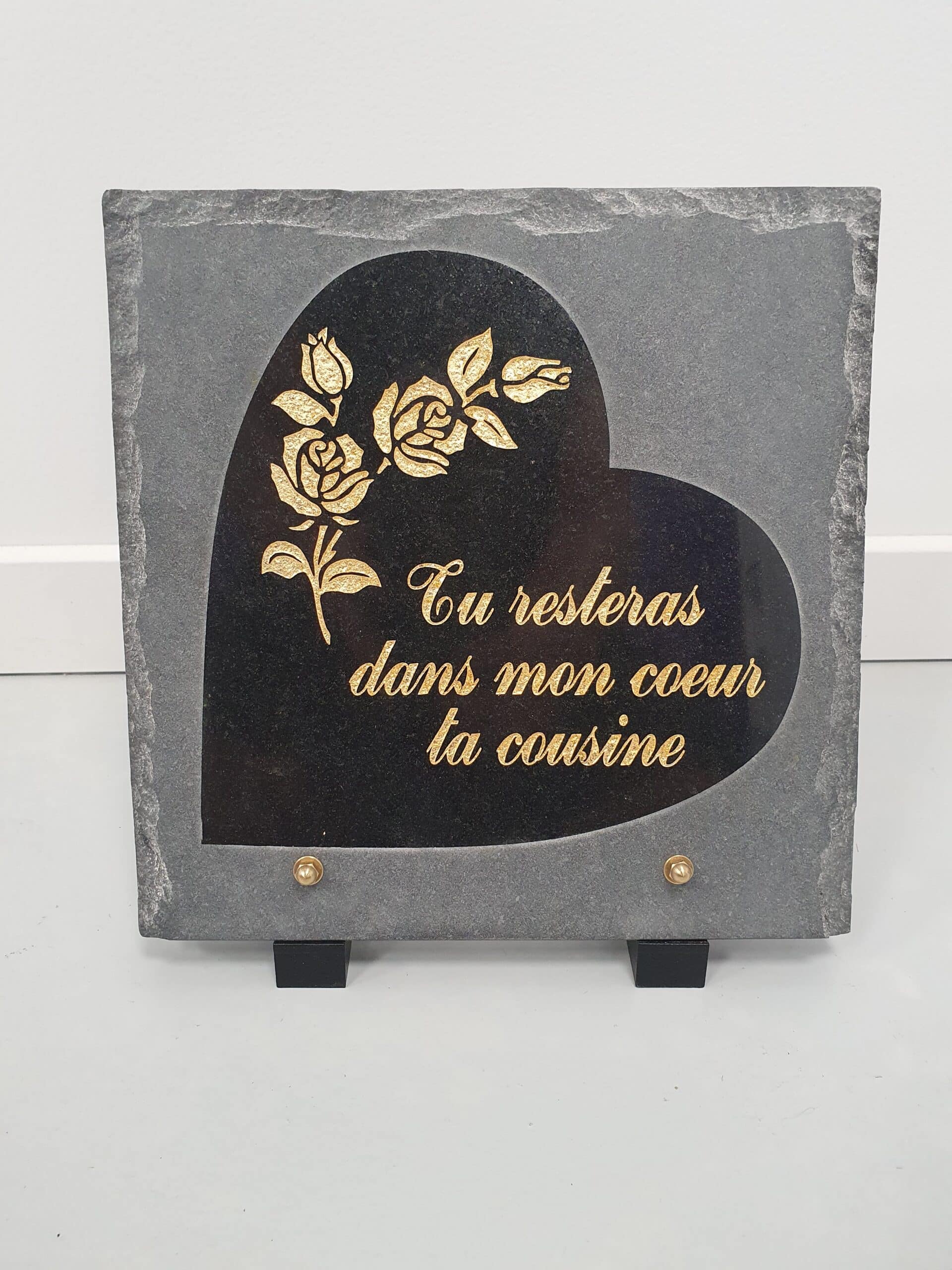 Plaque funéraire cœur en granit noir avec roses dorées : "Tu resteras dans mon cœur ta cousine".