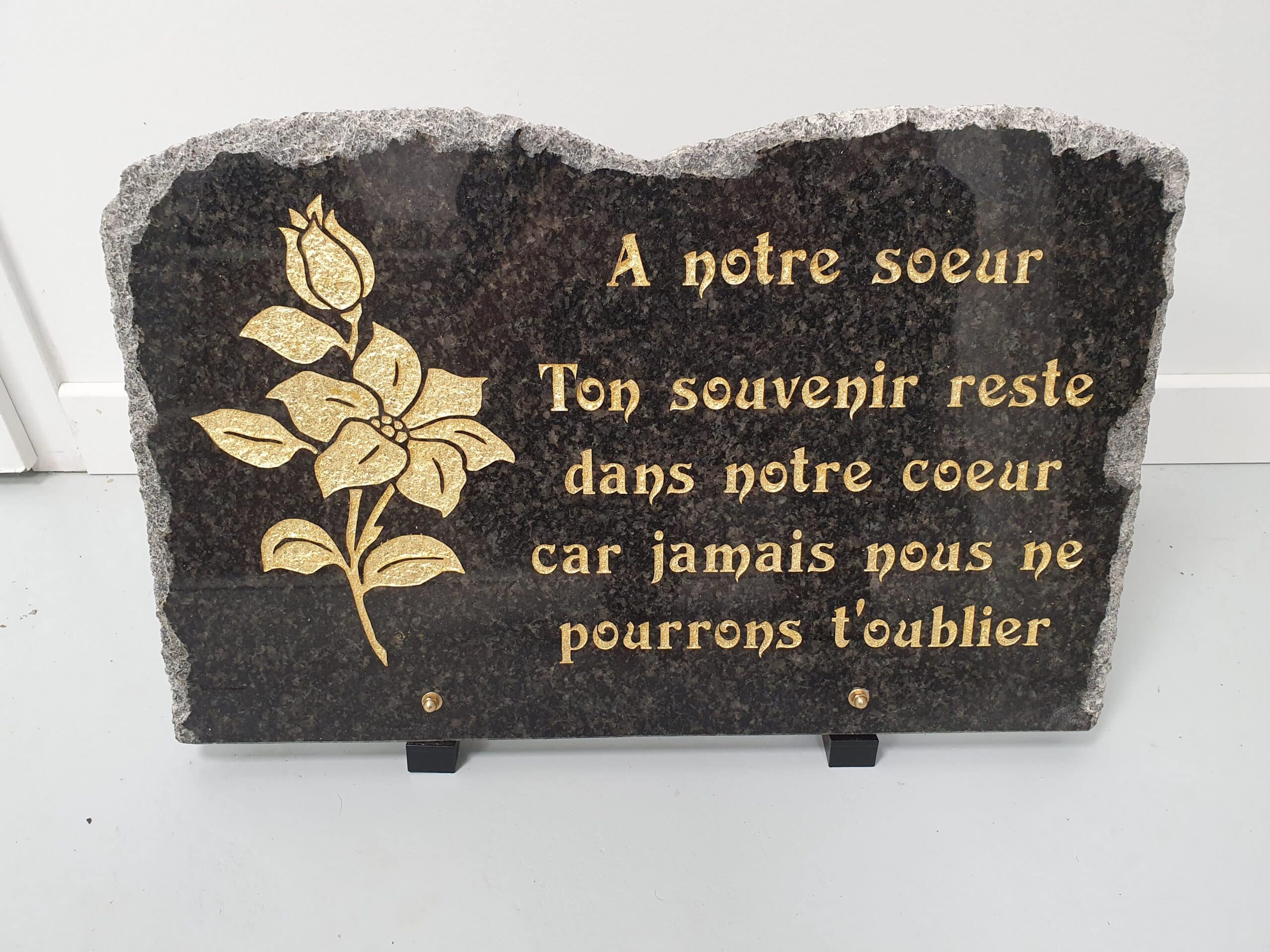 Plaque funéraire en granit noir, rose dorée et message hommage "À notre sœur, ton souvenir reste dans notre cœur".