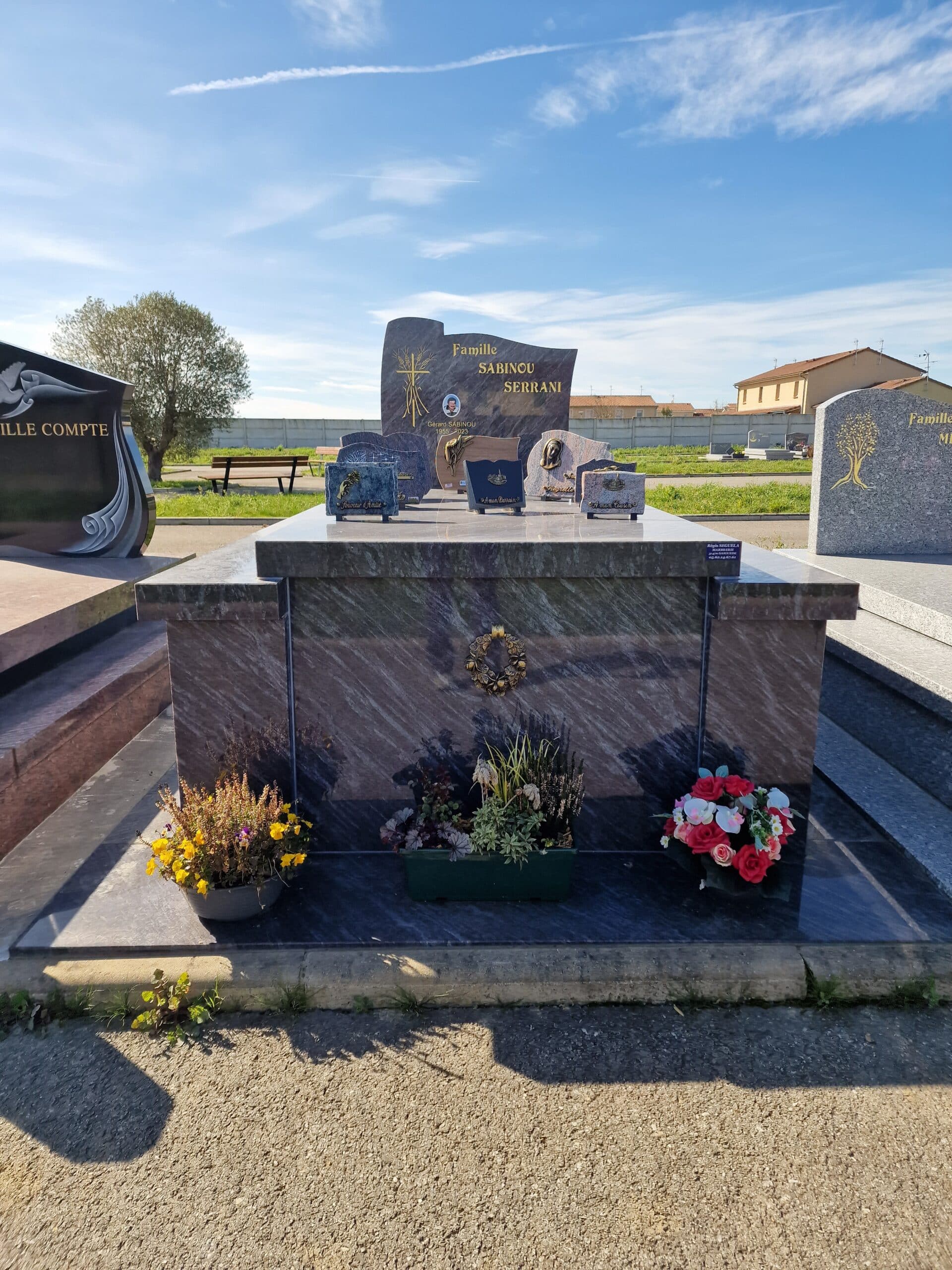 Monument funéraire Famille Sabinou Serrani en granit veiné avec fleurs et portrait de Gérard Sabinou (1955-2023).